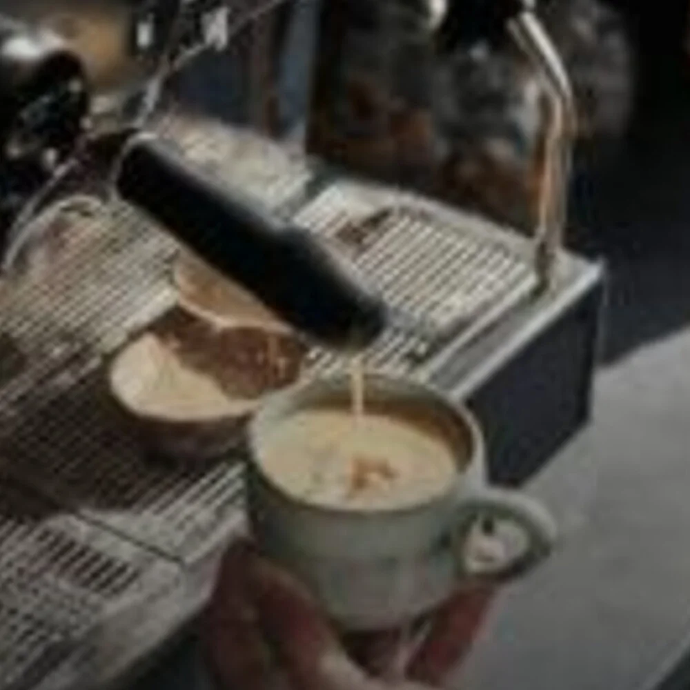 Milk being poured into a coffee cup